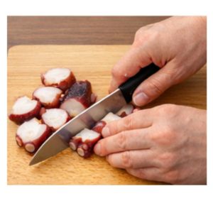 まな板の上でタコを一口大に切っている様子。やわらかく食べやすい大きさに切る工程。